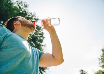 man drinking water in hot summer day. copy space