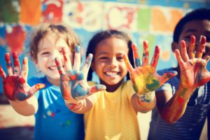 Happy diverse children raising painted hands kindergarten child kids playing playful joyful enjoying colorful paint inclusion concept school art education preschool illustration creativity creative