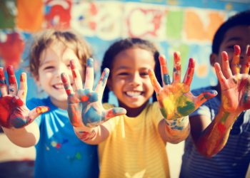 Happy diverse children raising painted hands kindergarten child kids playing playful joyful enjoying colorful paint inclusion concept school art education preschool illustration creativity creative. High quality photo